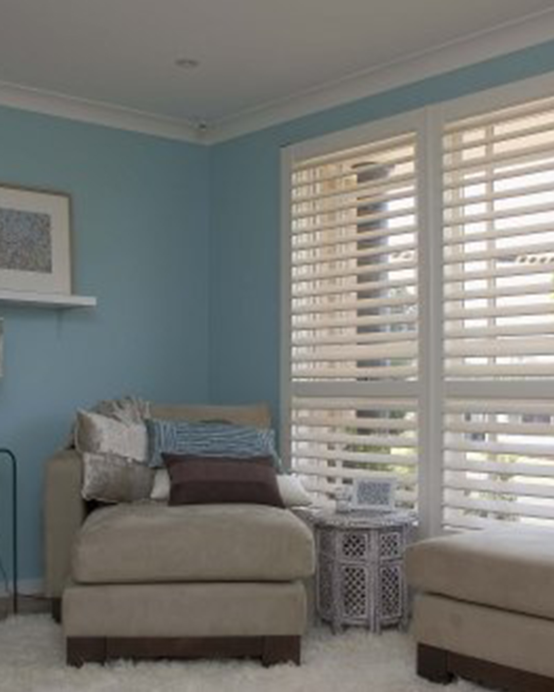 Classic wood interior shutters give windows in a tastefully arranged space appeal and usefulness.