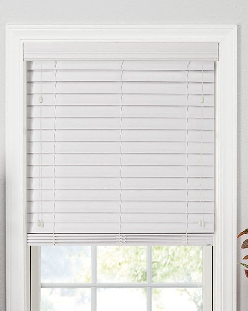 A window is elegantly covered with white composite blinds, giving the space a crisp, contemporary look.