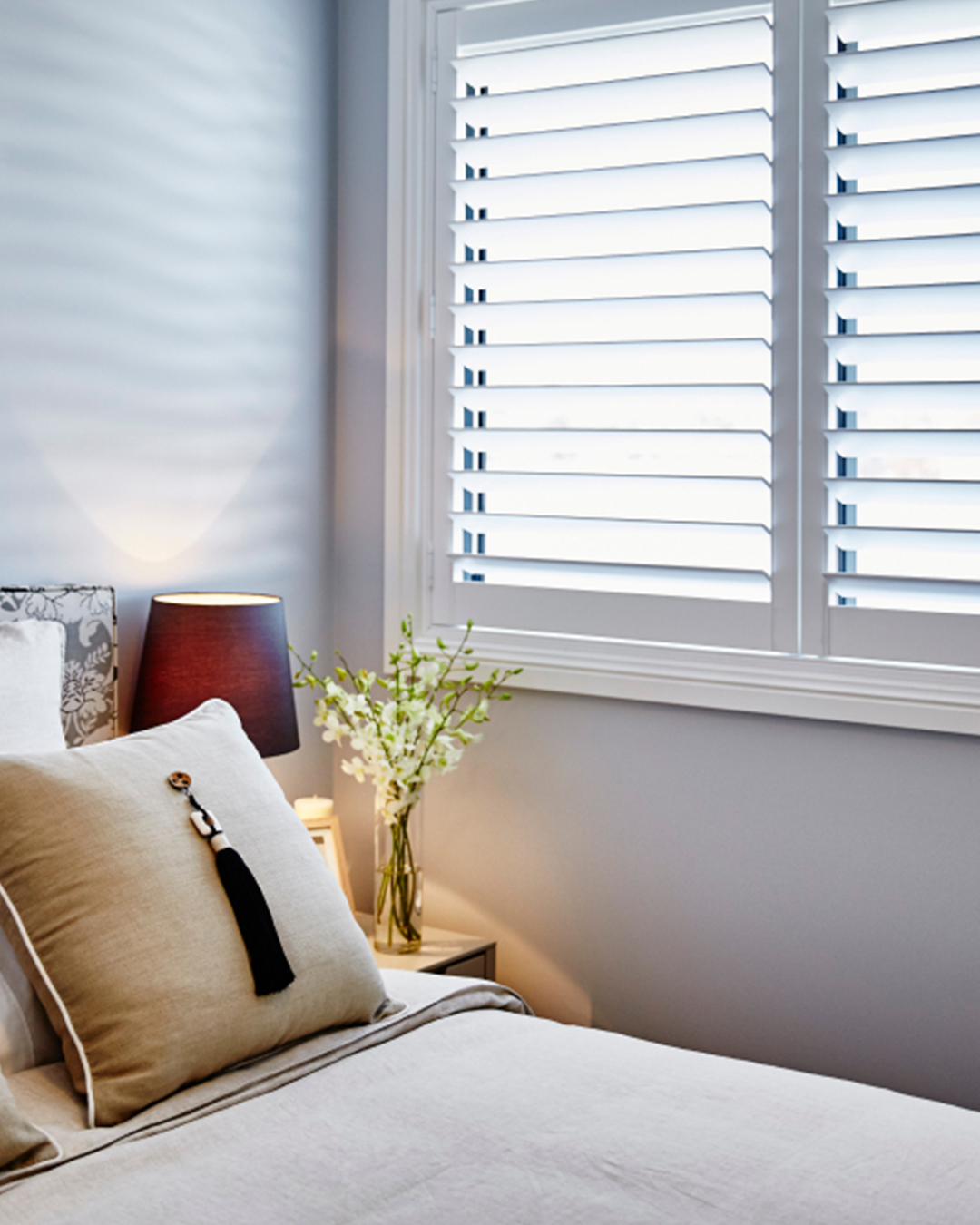 Neutral-toned modern poly shutters that improve the ambience and natural light in a tastefully furnished living area.