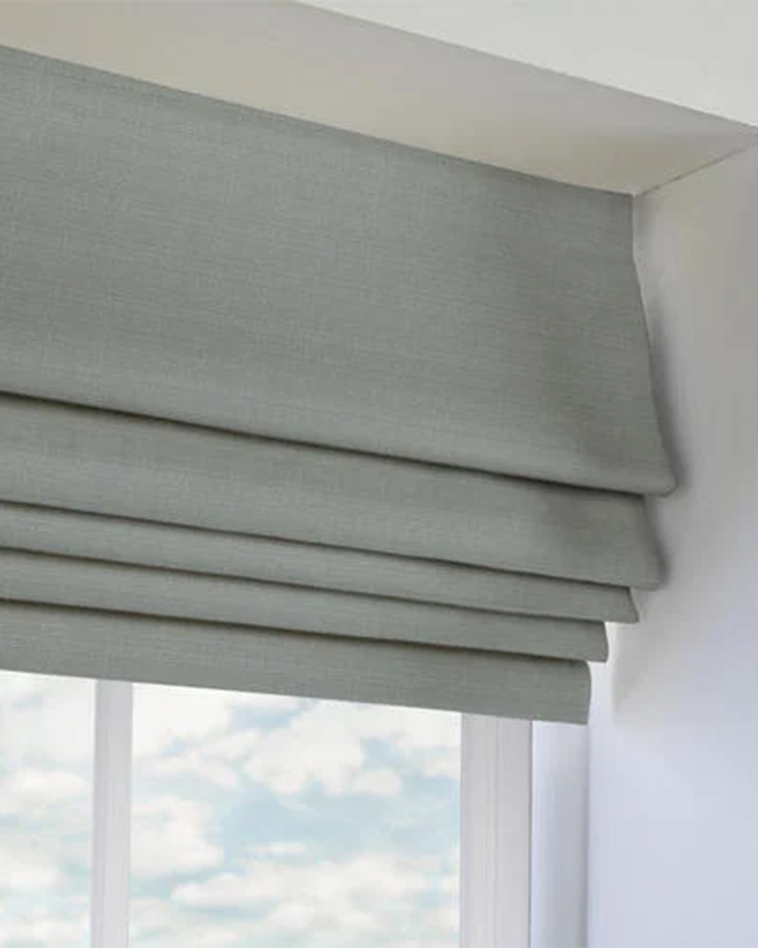 A window is adorned with delicate soft curtains that softly diffuse sunlight while enhancing the room's decor.