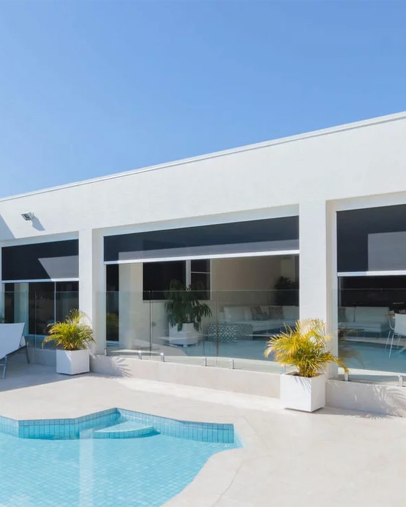 A patio with a zip screen installed that keeps views of the outside open while offering shade and insect protection.