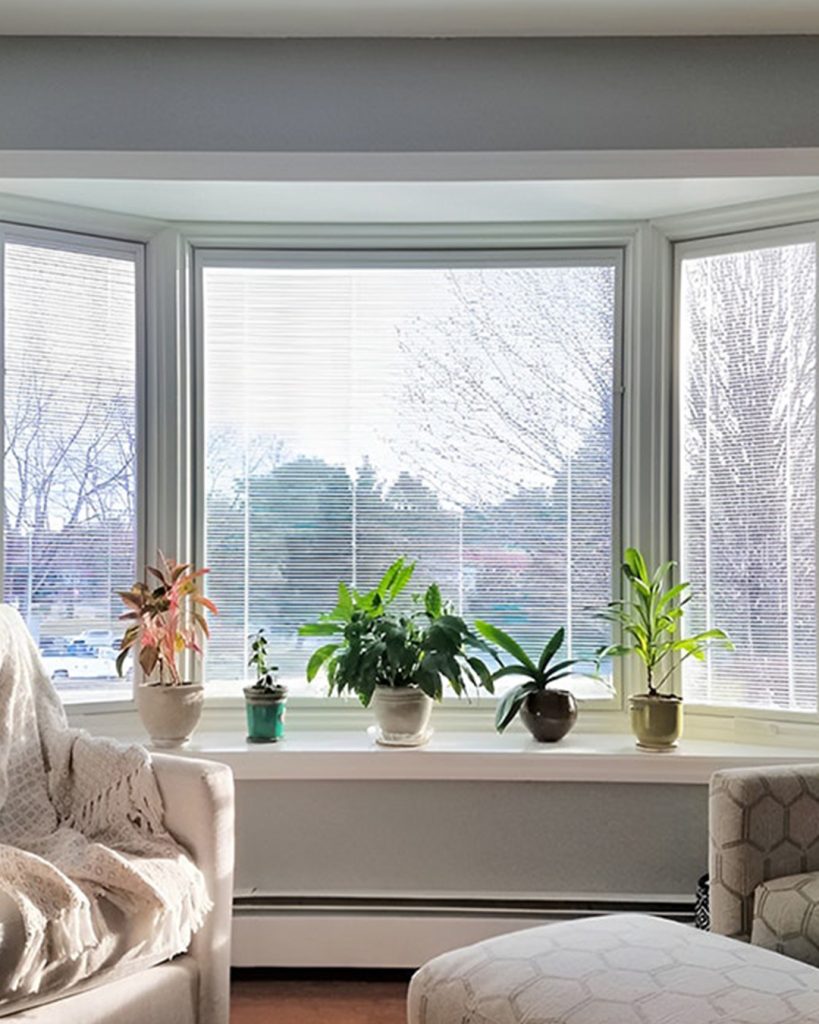 The room's visual appeal is enhanced by the elegant vinyl blinds that are partially closed, screening sunlight.