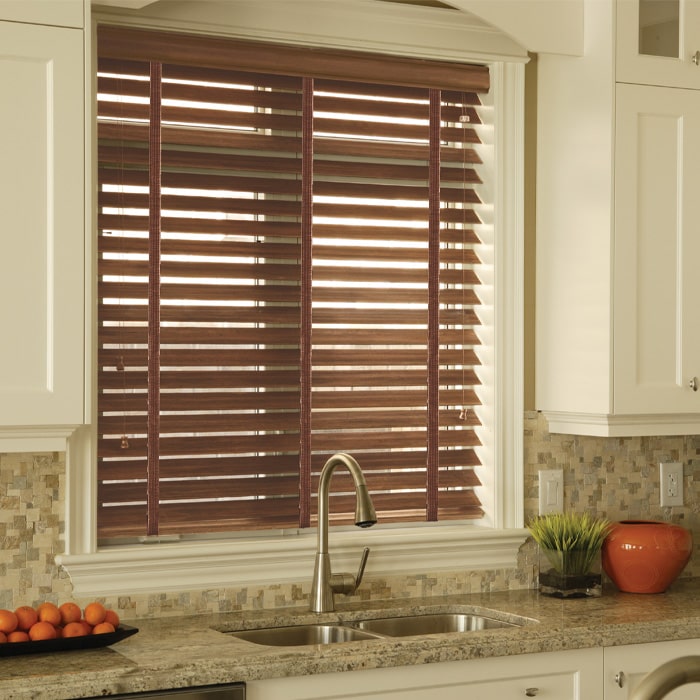 A window with faux wood blinds adds practicality and visual appeal to the space.